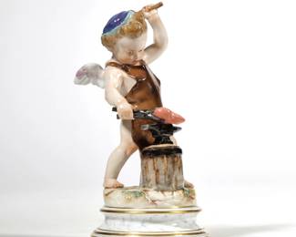 MEISSEN CUPID WITH ANVIL | Porcelain figure of Cupid "forging a heart", with underglaze blue crossed swords mark to bottom and no. 44 with incised numbers L114 and 101.  - h. 7.25 x dia. 3.75 in.


