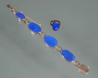 (2pc) LAPIS LAZULI & 14K GOLD SUITE | Comprising a bracelet of four oval lapis lazuli flat stones set in (tested to) 14k gold surrounds (6.75 in,) and a matching lapis ring (size 4.25); together 29.4g total weight, no apparent markings.
