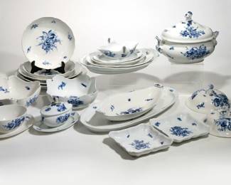 (20pc) MEISSEN BLUE FLOWER SERVING DISHES | Meissen China serving dishes, including: an oval serving dish [two repaired flakes along edge], a long serving platter (l. 21.5 in.) [a few imperfections to glaze along rim, firing crack to foot rim]; two square dishes with shaped rims [one with chips / repairs to edge]; two square serving bowls [each with single firing crack to footrim] ; a 14-inch round serving platter, two 12.5-inch serving platters [one with repaired rim], two 10-inch serving bowls [both with cracks]; three nesting oval serving dishes (largest 16 in.) [smallest with repaired chip to rim]; an oval lidded tureen [two repaired chips on lip of lid, glaze imperfection on lid]; an oval serving bowl and attached underplate [repaired plate rim]; a lidded sauce boat with attached underplate [repaired finial and plate rim]; an open gravy boat with attached underplate [cracks at handles]; and two 8.75-inch round dish covers.
