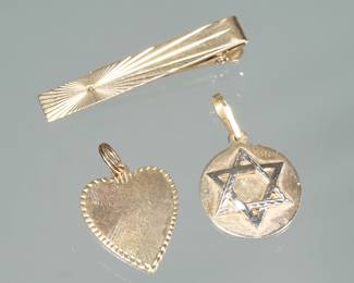 (3pc) 14K GOLD PENDANTS & TIE CLIP | Including a mixed religion charm (one side impressed "Saint Christopher Protect Us" the other mounted with a Star of David (0.75 in., 4.1g), a heart form charm (1 in., 3.3g), and an engraved hinged tie clip (1.75 in., 4.6g)

