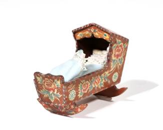 NATASHA PAINTED DOLLHOUSE CRADLE | Dollhouse miniature cradle with hand-painted decoration, with baby inside; signed "Natasha", inscribed and dated on bottom, "Carl L Anderson / near Marlborough Mass / March 10, 1977"
 - l. 3.5 x w. 2 x h. 2.75 in.