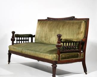 AESTHETIC PERIOD ROSEWOOD SETTEE | Late 19th century, profusedly carved and decorated; the crest rail with a central incurved section having a brass-inlaid bell flower device over floral relief carving with stippling, upholstered armrests over turned supports with oversized melon gadrooned carvings scroll carved hand holds - l. 66 x w. 28 x h. 38.5 in.
