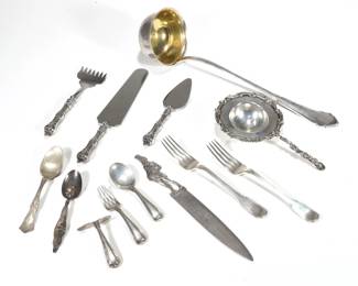 MISC. STERLING & 800 SILVER FLATWARE | Sterling silver flatware pieces, including a pair of Tiffany & Co. forks; a three-piece English child's flatware set, a Micawber letter opener, 2 spoons, and a three piece silver-handled dessert serving set; total weighable sterling 10.86 ozt; plus two 800 silver items: a tea strainer with ornate scrolling acanthus pattern and a ladle with gilt bowl, together 10.6 ozt - l. 12.5 in. (largest)
