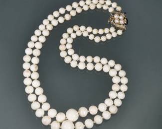 WHITE CORAL & 14K GOLD GRADUATED DOUBLE STRAND NECKLACE | Designed as two hand, strong lines of graduated white coral beads (ranging from 14.5 to 6.2mm diameter), the two strands terminating in a (tested to) 14 K white gold clasp, mounting for pearls and four small faceted sapphires; 18 in., 85.7g total weight.
