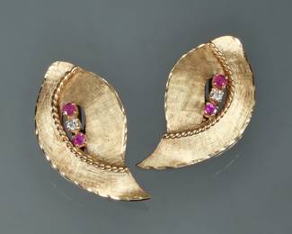 PAIR DIAMOND, RUBY & 14K EARRINGS | Postless / clip-on 14k yellow gold leaf or shell-form earrings with engraved texture, each mounting two rubies flanking a single round diamond, with fineness mark on the clasp; 7.7g

