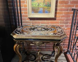 Tuscan style, center table with inlay center and Greek inspired figures at the base.  38"l x 30"h x 25"d. 