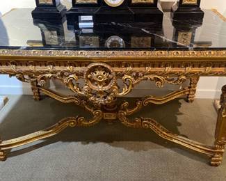 French Rococo style table with black marble top carved gold leaf wood frame measuring 64"l x 40"w x 32"h