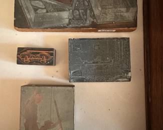 Four antique wood block stamps, brass, linoleum, and metal.  Subjects are an office layout, military men holding missed rocket, Opera  glasses, newspaper ad.