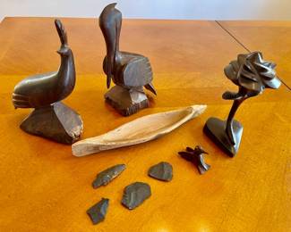 Lot 055-K: Carved Wood Décor 

Features: 
•	Beautifully polished dark figures of a flower, hummingbird, pelican and quail
•	Other items include a rustic canoe and arrowheads

Dimensions: For reference: the pelican is 8.5”H

Condition: Canoe is rustic. Other wood pieces are nicely polished.


