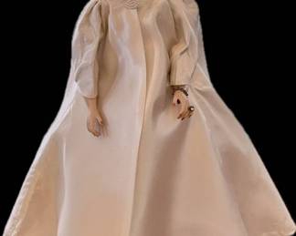 Lot 005a-ER: Vintage Madame Alexander Jackie Kennedy Doll

Features: 
•	Freshly coiffed, re-assembled with new elastics, and recently “gone over” by a Nashville-area doll restoration expert
•	Dressed in her inaugural gown and outfit
•	Includes stand and several additional outfits and accessories
•	For local bidders only (those not requiring shipping): Vintage Cass Toys Travel Trunk


Dimensions (doll): s

Condition:
•	Doll: Good pre-owned condition. Some light reddish discoloration is visible on a few parts of her body from fabric dye bleed-through several decades ago.
•	Case: Good pre-owned condition; some age-and-wear-related oxidation on outside top surface. See photos for additional details. 
