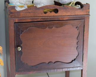 Closeup of Georgian bedside cabinet / nightstand, standing on tapered legs and features a shaped gallery with pierced handles