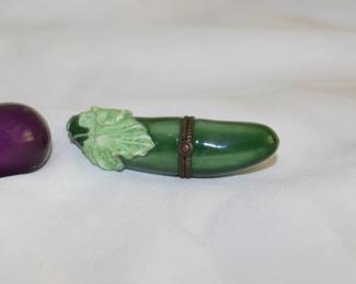 Closeup of charming vintage porcelain enameled lidded boxes in cucumber and eggplant form
