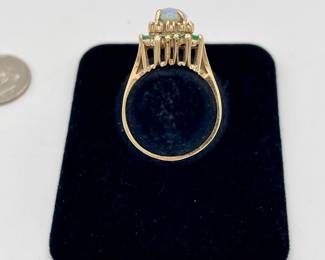 10k gold ring with central opal surrounded by stepped row of diamonds and emeralds