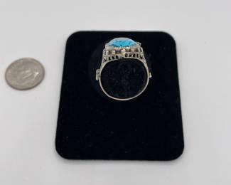 Side view of sterling silver ring with blue stone, possibly topaz