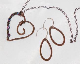 Close up of delicate copper link necklace with hammered copper wire and beaded heart pendant, matching hammered copper earrings