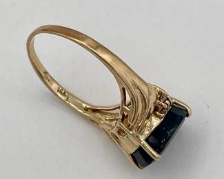 Closeup of 14k gold ring with large very dark sapphire and small side diamonds