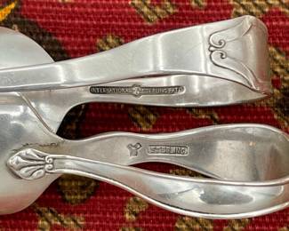 Another closeup of sterling silver and silver plate serving spoons, teaspoons, sugar tongs, salad serving set