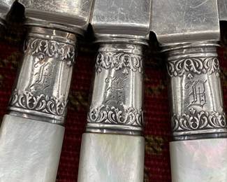 Closeup of the set of 9 mother of pearl handle luncheon knives with sterling silver collars. Landers Frary Clark Aetna Works