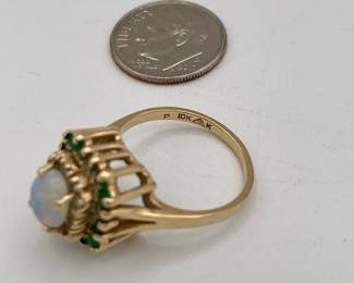 10k gold ring with central opal surrounded by stepped row of diamonds and emeralds