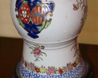 Closeup of antique Chinese porcelain blue and white gu form vase with overglaze floral and armorial enamels, converted to vase with shade and carved wooden base