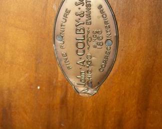 Closeup of John A. Colby & Sons coffee table's makers metal plate on underside of table