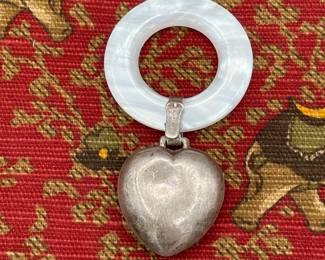 Reverse side of vintage baby rattle, mother of pearl with sterling silver heart attached