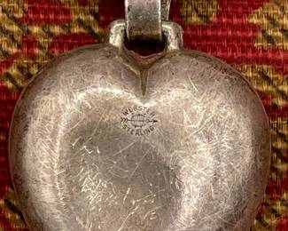 Closeup of vintage baby rattle, mother of pearl with sterling silver heart attached
