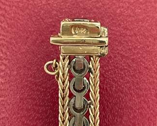 Closeup of clasp of 14k gold and diamond tennis bracelet