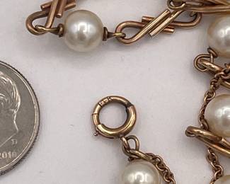Closeup of 14k gold figure-eight link and cultured pearl bracelet, with safety chain