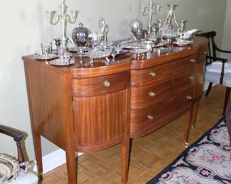 Stunning bow front sideboard, 3 central drawers flanked by single drawers and cabinet doors, displaying just part of the collection of antique silver plate tableware