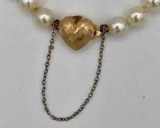Closeup of cultured pearl bracelet with 14k gold heart-shaped clasp
