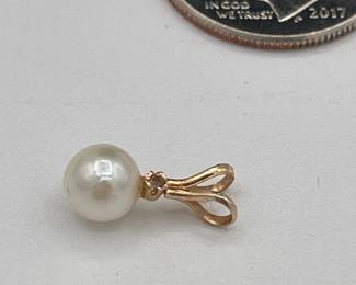 Closeup of pearl and gold pendant