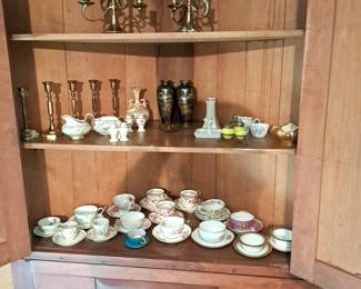 Cups & saucers and brass candlesticks.