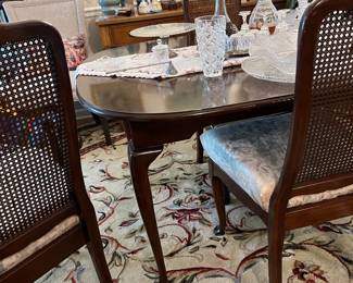 Queen Anne Table with 3 cane back chairs, round wool rug