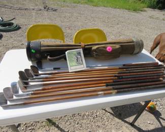 Lot 340. Eight wood-shafted golf clubs and a vintage bag.