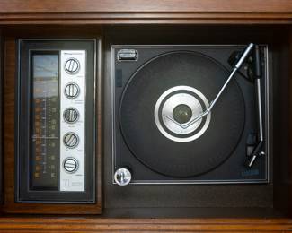 Measures 50 3/8” W x 19 1/4“ D x 29 1/2” T
Vintage 1960s Magnavox ‘Astro Sonic’ stereo console turntable walnut cabinet. Phonograph model 151293-1. Two sliding top doors reveal a 78/33/45/16 rpm turntable with manual and auto settings, and an AM/FM tuner. On the opposite side is space for albums, plus additional storage space. Comes with casters for rolling.