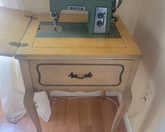 White sewing machine in cabinet