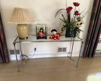 Glass Top Console Table, Lamp, Dolls, Floral Arrangement