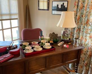 Desk by Sleigh with turned legs, porcelain lamp, desk accessories, and tea cups/saucers