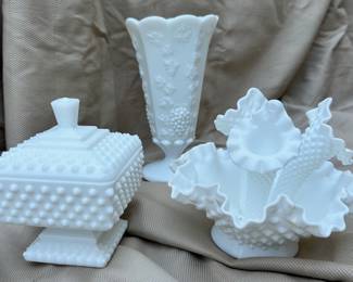 Fenton hobnail pedestal footed candy dish (left). Grape vines milk glass vase (rear center). Fenton ruffled three horn epergne flower vase (right).