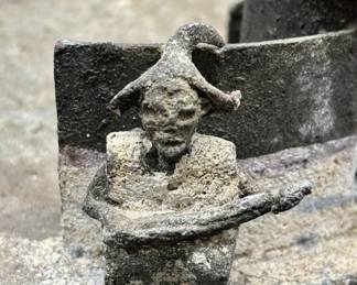 Bronze African Village Diorama Sculpture Found In Old House In Atlanta, Georgia. This primitive sculpture is one of two, along with other African artifacts, found behind an inside wall of an old home in Atlanta, Georgia while it was being torn down. The origins and creator of the sculpture are unknown. The sculpture/diorama features a tribal village scene with four huts surrounded by a wall. A watchful tribesman is standing outside the village entrance while a sleeping dog lays on the opposite side of the entrance. Inside, two village women prepare food in large pots while a cat slinks around the perimeter of the wall. There are four huts with removable bronze roofs. One of the tribal women has broken arms, one of which is present. Beyond that, the set is well preserved overall. The sculpture diameter is approximately 9 inches and the weight is 2 lbs