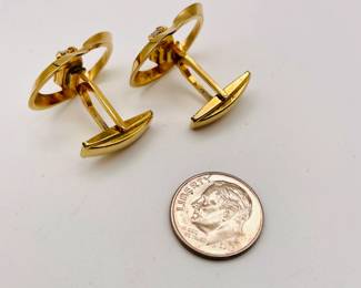 Another view of pair of cufflinks in gold tone metal, oval bands holding clear emerald cut stones