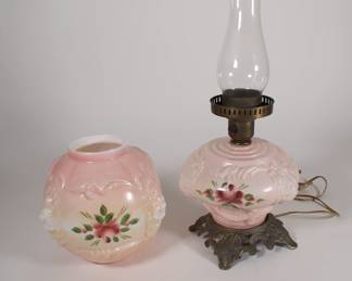 Antique glass lion head rose hurricane lamp on ornate metal base, converted to electricity