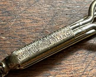 Closeup of SWANK brand sterling silver tie clip with helmeted warrior cameo suspended on chain