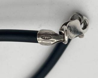 Closeup of sterling silver and mother of pearl modernist pendant on cord necklace with sterling clasp