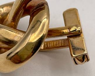 Closeup of cufflinks by SWANK, gold toned metal, knots shape