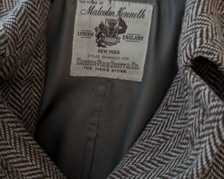 Closeup of men's wool lined herringbone coat, 3/4 length, label "The House of Malcom Kenneth, London England / New York, styled expressly for Carson Pirie Scott & Co., The Men's Store" 