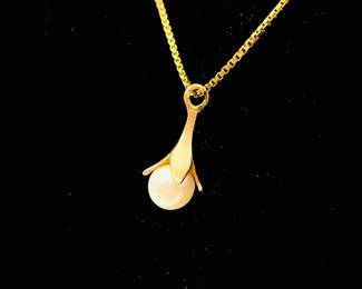 Closeup of 14kt gold necklace with pearl pendant