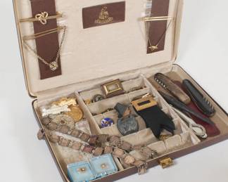 Jewelry case containing tie bars and tacks, corkscrews, bracelets, badges