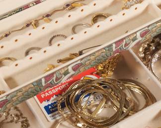 Closeup of women's jewelry box containing rings, necklaces, earrings, bracelets, and brooches 
